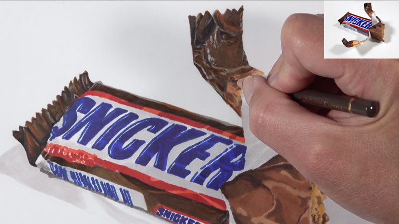 Initial applications of colored pencils over the marker underpainting on the candy bar wrapper