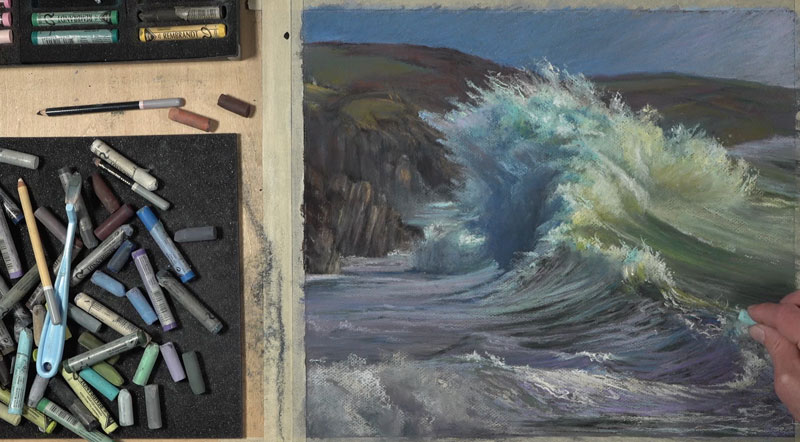 Finishing touches to the drawing of a wave with pastels